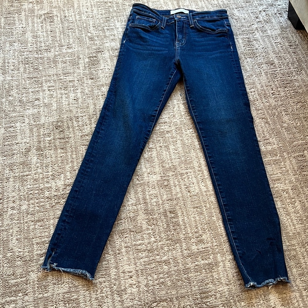 Dark blue jeans with shredded, slitted bottoms